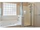 Main bath featuring soaking tub and shower separated by a glass partition and a glass block window at 10368 E Gold Nugget Ct, Gold Canyon, AZ 85118