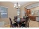 Cozy dining area with a dark wood table, chandelier, and a view into the kitchen at 10421 W Via Del Sol -- # 379, Peoria, AZ 85383