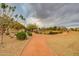 Scenic community walking path lined with lush landscaping, mature trees, and a view of a nearby park at 10421 W Via Del Sol -- # 379, Peoria, AZ 85383