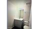 Bathroom featuring a gray vanity, toilet, and large mirror at 12221 W Bell Rd # 119, Surprise, AZ 85378