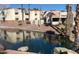 Waterfront condominium complex with red tile roofs, lush landscaping, and palm trees at 12221 W Bell Rd # 119, Surprise, AZ 85378