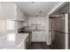 Bright kitchen features white cabinetry, modern appliances, and breakfast bar at 12221 W Bell Rd # 119, Surprise, AZ 85378
