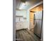 Kitchen featuring stainless steel refrigerator, white cabinets and countertop, and wood floors at 12221 W Bell Rd # 119, Surprise, AZ 85378