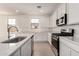 Bright kitchen with white cabinets, quartz countertops, stainless steel appliances and wood-look tile floors at 12361 W Marguerite Ave, Avondale, AZ 85323