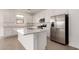 Spacious open kitchen with a large island, stainless steel appliances and wood-look tile floors at 12361 W Marguerite Ave, Avondale, AZ 85323