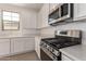 Close-up of modern kitchen featuring a stainless steel range, quartz countertops and white cabinets at 12361 W Marguerite Ave, Avondale, AZ 85323