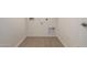 Clean laundry room with tile flooring, utility connections, and a fresh coat of paint at 12361 W Marguerite Ave, Avondale, AZ 85323