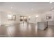 Spacious open-concept living room featuring sliding glass doors, white walls and wood-look tile floors at 12361 W Marguerite Ave, Avondale, AZ 85323