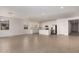 Large living area with an open layout connecting to the kitchen, featuring wood-look tile floors and white walls at 12361 W Marguerite Ave, Avondale, AZ 85323