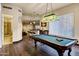Open game room with a pool table, hardwood floors, and an adjacent bar area at 14725 N Mariposa Ct, Fountain Hills, AZ 85268