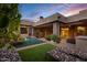 Stunning backyard featuring a rock pool, lush landscaping, covered patio, and outdoor seating at 14725 N Mariposa Ct, Fountain Hills, AZ 85268
