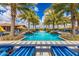 A beautiful pool area is surrounded by palm trees and plenty of lounge seating at 1474 E Elysian Pass, Queen Creek, AZ 85140