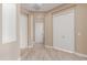 Hallway view showcases light tile floors and a neutral wall color scheme; the space is bright and has multiple doors and closets at 1474 E Elysian Pass, Queen Creek, AZ 85140