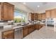This kitchen includes stainless steel appliances, custom tile backsplash, and granite countertops, creating an elegant cooking space at 1474 E Elysian Pass, Queen Creek, AZ 85140