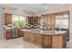 Spacious kitchen features stainless steel appliances, granite counters, custom backsplash, and a center island with a gas cooktop at 1474 E Elysian Pass, Queen Creek, AZ 85140