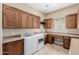 Well-equipped laundry room boasts ample cabinetry, counter space, and modern washer and dryer units for added convenience at 1474 E Elysian Pass, Queen Creek, AZ 85140