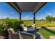 Comfortable outdoor seating area overlooks manicured lawn and golf course views, perfect for relaxation and entertainment at 1474 E Elysian Pass, Queen Creek, AZ 85140