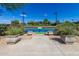 Community tennis courts with manicured planters leading to a gated entrance and a blue sky above at 1474 E Elysian Pass, Queen Creek, AZ 85140
