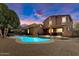 Beautifully lit backyard featuring a private pool and covered patio, ideal for evening relaxation at 15260 W Alexandria Way, Surprise, AZ 85379