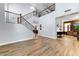 Open-concept living area with hardwood floors and elegant staircase at 15260 W Alexandria Way, Surprise, AZ 85379