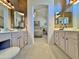 Double vanity bathroom with vanity lighting, a window, and an arched doorway to the bedroom at 15720 S Lanai Cir, Arizona City, AZ 85123