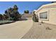 Beige single-story home with a large driveway, desert landscaping, and a two-car garage at 15720 S Lanai Cir, Arizona City, AZ 85123