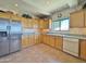 Efficient kitchen with light wood cabinetry, stainless steel appliances, and tile flooring for easy maintenance at 15720 S Lanai Cir, Arizona City, AZ 85123