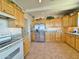 Well-equipped kitchen featuring light wood cabinetry, stainless steel appliances, and tile flooring at 15720 S Lanai Cir, Arizona City, AZ 85123