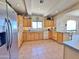 Practical kitchen featuring ample light wood cabinets, tile flooring, and stainless steel refrigerator at 15720 S Lanai Cir, Arizona City, AZ 85123