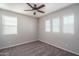 A simple, empty bedroom with large windows providing ample natural light and neutral carpet at 16227 W Mariposa Grande --, Surprise, AZ 85387