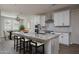 Staged kitchen featuring white cabinets, granite countertops, breakfast bar, and dining area at 16227 W Mariposa Grande --, Surprise, AZ 85387