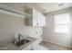 Well-lit laundry room with a utility sink, cabinets, and washer/dryer hookups at 16227 W Mariposa Grande --, Surprise, AZ 85387