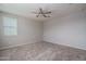 Neutral carpeted bedroom with a ceiling fan and a large window at 16277 W Mariposa Grande --, Surprise, AZ 85387