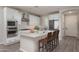 Bright kitchen featuring white cabinets, stainless steel appliances, and a center island with chairs at 16277 W Mariposa Grande --, Surprise, AZ 85387