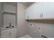 Functional laundry room with sink, white cabinets for storage, and ample counter space at 16277 W Mariposa Grande --, Surprise, AZ 85387