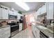 Modern kitchen with stainless steel appliances, granite countertops, and white cabinets at 16645 N 103Rd Ave, Sun City, AZ 85351