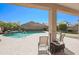 Relaxing backyard boasts a refreshing pool with a small waterfall feature, complemented by a putting green and lounge area at 16763 W Adams St, Goodyear, AZ 85338