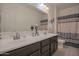 Bathroom featuring dual sinks, a large mirror, and a shower-tub combo for efficient space utilization at 16763 W Adams St, Goodyear, AZ 85338