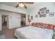 Carpeted bedroom offering a comfortable bed, a ceiling fan, and a view into a connecting hallway and stairs at 16763 W Adams St, Goodyear, AZ 85338