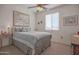 Bright bedroom showcasing a ceiling fan, a large window, and a neutral color palette, creating a soothing retreat at 16763 W Adams St, Goodyear, AZ 85338