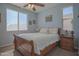 Comfortable bedroom with a wood bed frame, ceiling fan, and natural light from two windows at 16763 W Adams St, Goodyear, AZ 85338