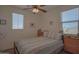 Well-lit bedroom with dual windows, ceiling fan, and neutral decor creating a relaxing and inviting atmosphere at 16763 W Adams St, Goodyear, AZ 85338