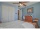 Bedroom featuring a bed with white linens, ceiling fan, closet, and wood dresser at 16763 W Adams St, Goodyear, AZ 85338