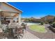 Spacious outdoor living area with comfortable seating, dining space, a putting green and a sparkling pool at 16763 W Adams St, Goodyear, AZ 85338