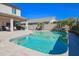 Inviting swimming pool with waterfall feature, surrounded by a patio, outdoor kitchen, and lush landscaping at 16763 W Adams St, Goodyear, AZ 85338