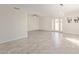 Open-concept living area features modern light fixture, neutral paint, and wood-look tile flooring at 18211 N 24Th Ave, Phoenix, AZ 85023