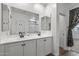 Bathroom featuring double sinks, a large mirror, and a separate toilet room at 18369 W La Senda Dr, Surprise, AZ 85387