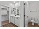 A well-appointed bathroom featuring double sinks, wood floors, and a door to the toilet at 18369 W La Senda Dr, Surprise, AZ 85387
