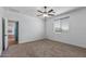 A light bedroom with plush carpeting, a ceiling fan, and a large window at 18369 W La Senda Dr, Surprise, AZ 85387