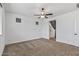 A cozy bedroom featuring plush carpeting, a ceiling fan, and an en-suite bathroom at 18369 W La Senda Dr, Surprise, AZ 85387
